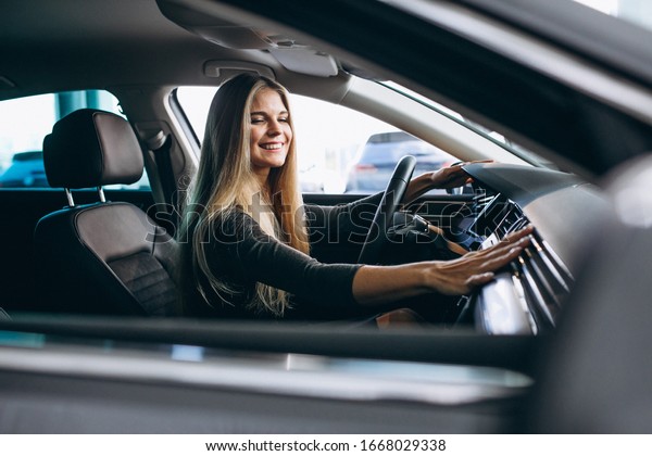 Young woman\
testing a car from a car\
showroom