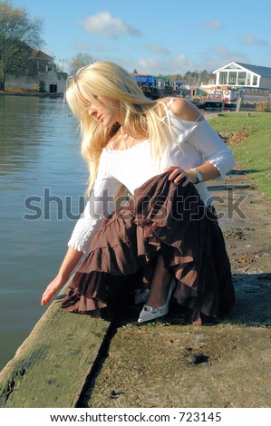 Young woman testing the waters by the river