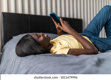 Young Woman Texting In The Bed