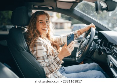 Young woman texting on her smartphone while driving a car - Powered by Shutterstock