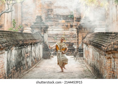 A young woman in a Thai dance dress is dancing in a old temple thailand. Khon thai ramayana.