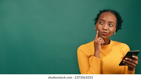 Young woman thinking has idea what to text, green studio background - Powered by Shutterstock