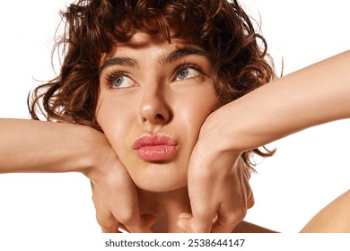 A young woman thoughtfully gazes up while resting her chin on her hands, conveying emotion. - Powered by Shutterstock