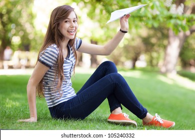 Young Woman Throwing Paper Plane