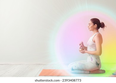 Young woman with Tibetan singing bowl cleansing aura on light background with space for text