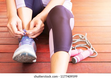 Young Woman Tie Shoelace Before Exercise Jump Rope