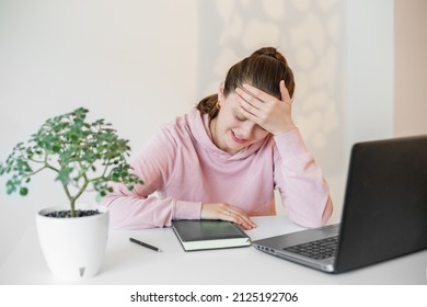 Young Woman Is Tired Of Working. Big Workload And Stress. Workplace With Table And Laptop.
