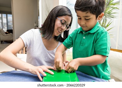 Young woman and toddler wrapping gifts in the evening at home - Powered by Shutterstock