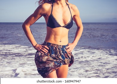 Young Woman With Toned Abs Standing On The Beach