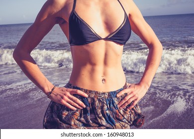 Young Woman With Toned Abs Standing On The Beach