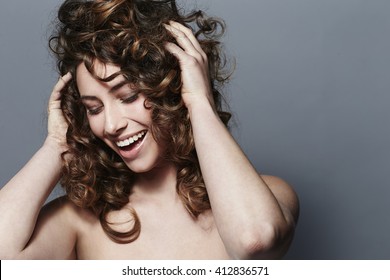 Young Woman Touching Curls, Smiling