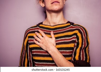 Young woman touching her chest