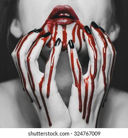 Young Woman Touching Her Face In Blood. Halloween And Horror Theme. Black And White Image With Red Elements