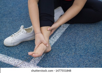 Young woman touching her painful ankle,suffering from ankle injury while exercising and running, Sport and exercise concept. - Powered by Shutterstock