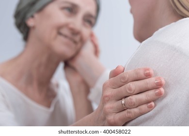 Young Woman Touching Her Sick Mother's Cheek. Older Woman With Scarf On Head Sick On Cancer