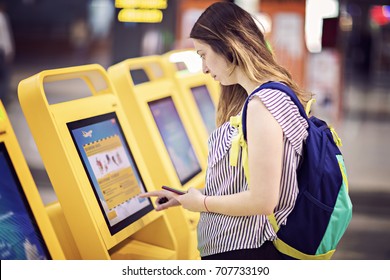 Young woman touching interactive screen to check in online