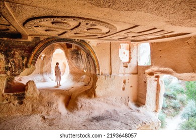 Young woman touring cave church of Three Crosses in Rose Valley in Cappadocia Turkey dated back to 10th century