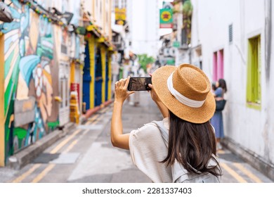 Young woman tourist with backpack walking at Haji Lane in Singapore