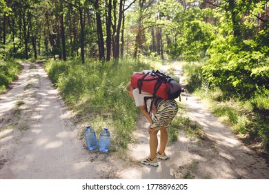 Young Woman, Tourist With A Big Bag Pack, Hiking Into The Wild Forest And Exhausted Of Heavy Burden, Wanted Drink Water