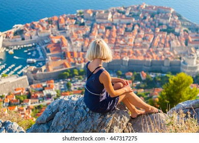 Young Woman Tourist Looks To The Old City Of Dubrovnik.