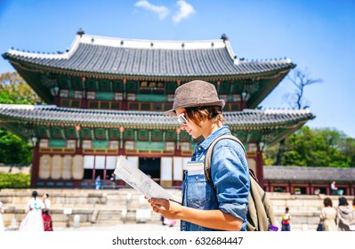 Young Woman Tourist With Map In Hand On The Background Of Asian Architecture, Travel To Korea, Seoul Asia