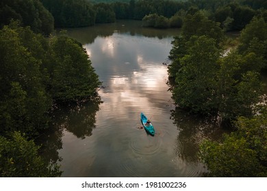 Young woman tourist paddling the kayak at Salak Khok mangrove forest with aerial drone shot, Koh Chang, Thailand - Powered by Shutterstock