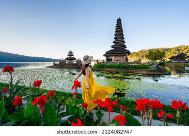 Young woman tourist relaxing and enjoying the beautiful view at Ulun Danu Beratan temple in Bali, Indonesia