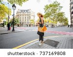 Young woman tourist walking with bag and catalan flag on the famous central boulevard in Barcelona city