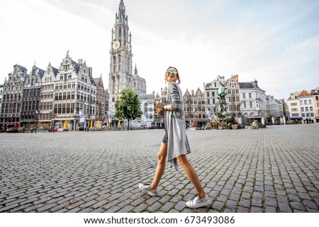 Young woman tourist walking on the Great Market square during the morning in Antwerpen, Belgium