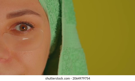 Young Woman With Towel On Head And Patches Under Her Eyes. Adult Female Courting Of Her Face In Domestic Conditions. Concept Of Fighting Wrinkles And Dark Circles Under Eyes. Close Up