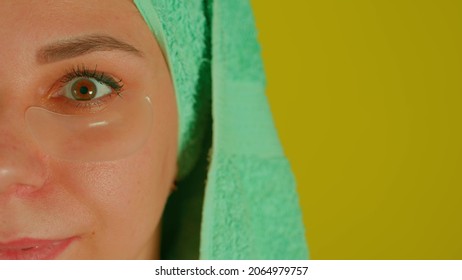 Young Woman With Towel On Head And Patches Under Her Eyes. Adult Female Courting Of Her Face In Domestic Conditions. Concept Of Fighting Wrinkles And Dark Circles Under Eyes. Close Up