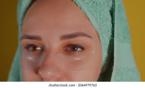 Young Woman With Towel On Head And Patches Under Her Eyes. Adult Female Courting Of Her Face In Domestic Conditions. Concept Of Fighting Wrinkles And Dark Circles Under Eyes. Close Up