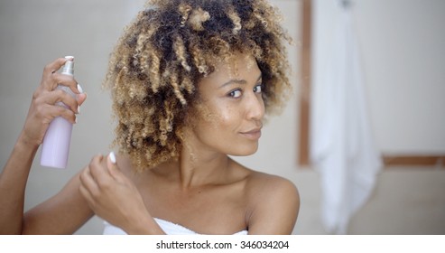 Young Woman In Towel Using Hair Spray In Bathroom 