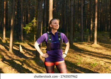 Young Woman Trail Runner Resting Between Jogging In The Evening Pine Forest