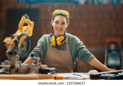 Young woman is training to be a carpenter in workshop. - Shutterstock ID 2157268517