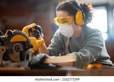 Young woman is training to be a carpenter in workshop.