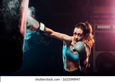 young woman training boxing in the punching bag - sport, self defense, boxing and training concepts - swing boxing - Powered by Shutterstock