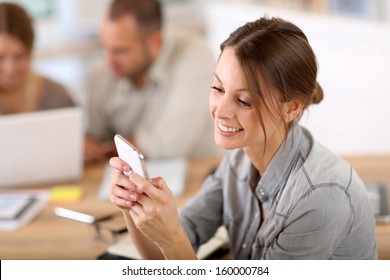 Young Woman In Training Class Sending Text Message