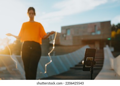 Young Woman Training Jumping The Rope While Streaming At An Urban Scenario.Exercising To Lose Weight