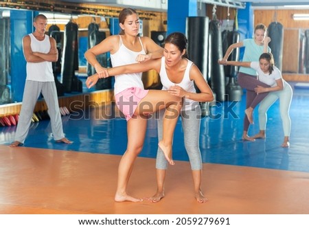 Young woman training knee strike during self protection class.