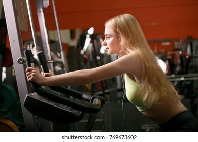 Young Woman Training On Bike In Gym