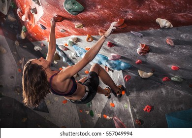 Young Woman Training On Practice Climbing Wall Indoor