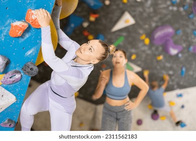 Young woman training rock climbing on the climbing wall - Powered by Shutterstock