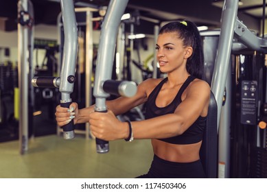 Young Woman Training Upper Body Using Fly Machine