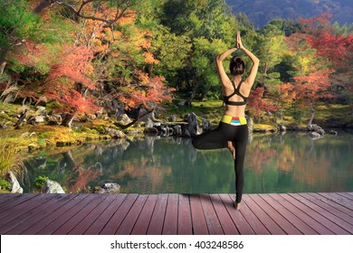 Young Woman Training Yoga Outdoor In Autumn Or Fall Park