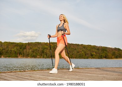 Young Woman Trains Fitness With Nordic Walking In The Fresh Air In Nature