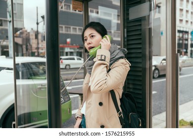 Young Woman Traveler Calling With City Call Box In Osaka Japan. Beautiful Lady Tourist With Backpack Talking On Payphone In Urban Street. Charming Female Tourist Having Conversation By Telephone.