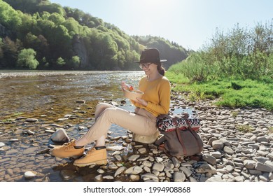 Young Woman Traveler Eat Healthy Food Near River On Nature Background