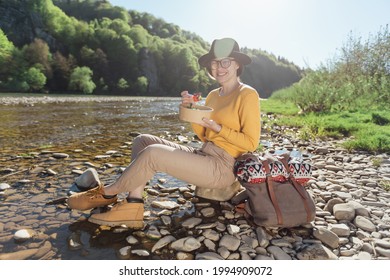 Young Woman Traveler Eat Healthy Food Near River On Nature Background