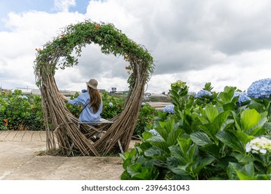 Young woman traveler enjoying with blooming hydrangeas garden in Dalat, Vietnam. Travel lifestyle concept